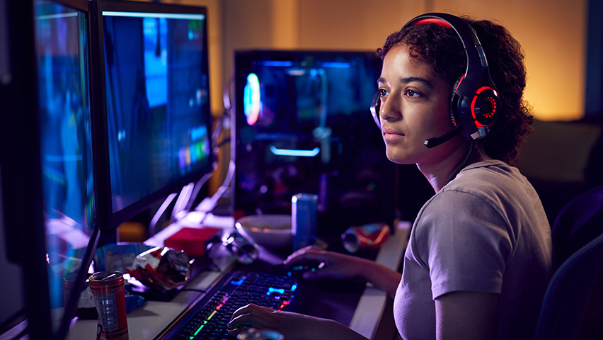 Girl wearing headset and uses computers for gaming