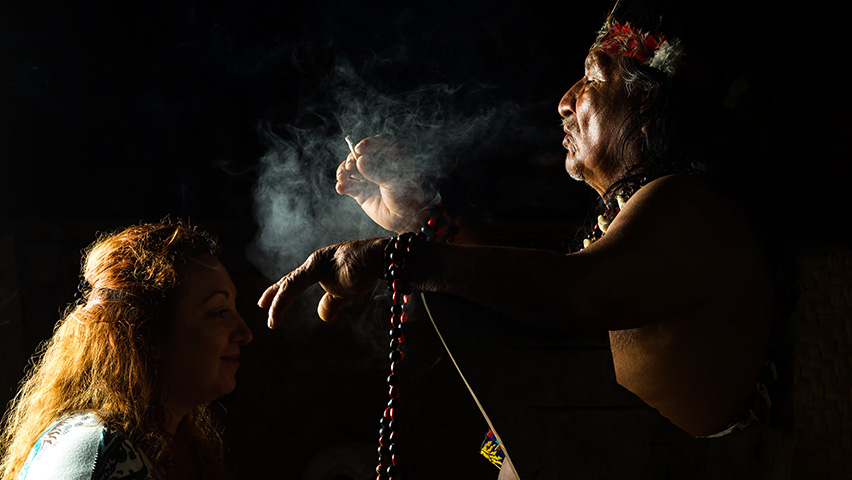 ancient Mayan shaman using plants for cultural healing on woman