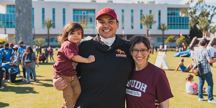 A family wearing Dominguez Hills clothes and hat.