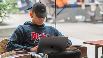 CSUDH student siting with laptop studying in Library 