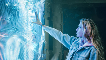 Woman reaching toward digital projection on wall