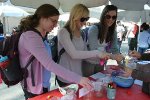 three ladies getting food from booth